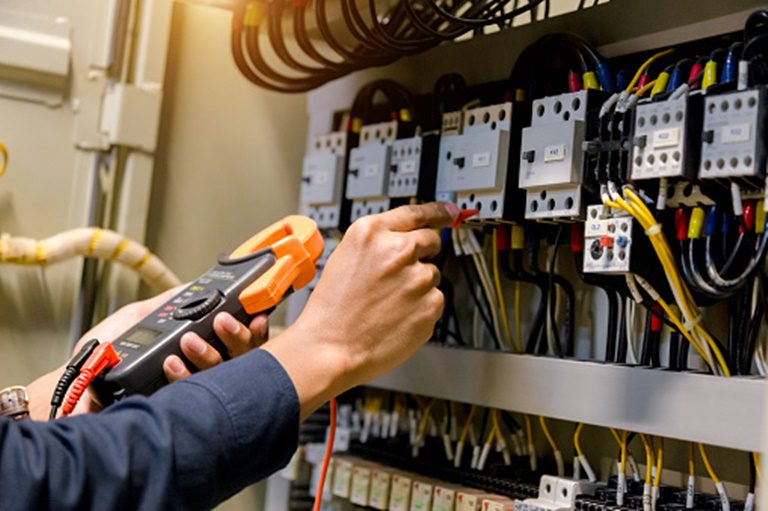 Local Electrician engineer work tester measuring voltage and current of power electric line in electrical cabinet control.